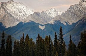 A natural heart shape in the snow peaked Rocky Mountains British Columbia Canada.  Photo taken at sunset