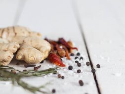 collection of spicy kitchen ingredients. rosemary, ginger, red chili, cloves, salt and pepper.