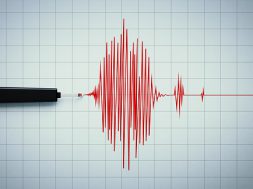 Seismograph recording seismic activity on grid paper. Horizontal composition with copy space. Earthquake concept.