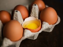 fresh-brown-eggs-broken-egg-with-yolk-eco-tray-made-from-recycled-paper-dark-wooden