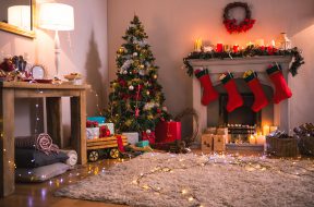 Christmas tree with presents near the fireplace at home in the living room