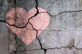 A broken heart. Drawing of a heart on a cracked wall. Broken relationships. Treason and betrayal. Past love. A quarrel.