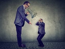 Angry business man boss screaming at himself small in megaphone