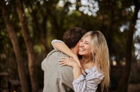 Carefree woman enjoying while embracing her boyfriend in spring day.