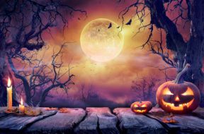 Jack O' Lantern With Candles In Violet Landscape With Full Moon