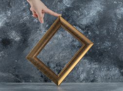 Female hand touching picture frame on marble background. High quality photo