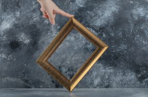 Female hand touching picture frame on marble background. High quality photo