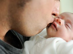 Father kissing his newborn baby girl. Close-up portrait